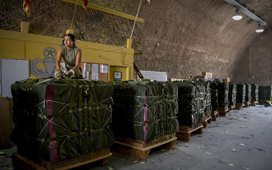 Army Spc. Monica Gutierrez of the 165th Quartermaster Company works on a bundle of humanitarian aid March 16, 2024, at Al Udeid Air Base in Qatar. Pallets containing more than 28,800 meals and 34,500 bottles of water were sent to Gaza by air the following day, U.S. Central Command said.