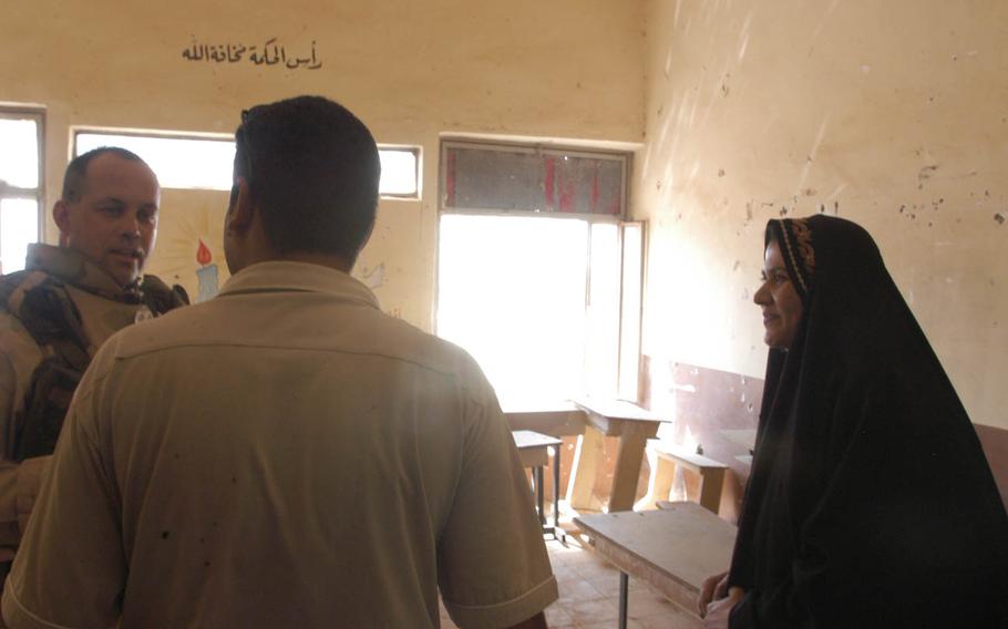 A soldier speaks to teachers in a classroom