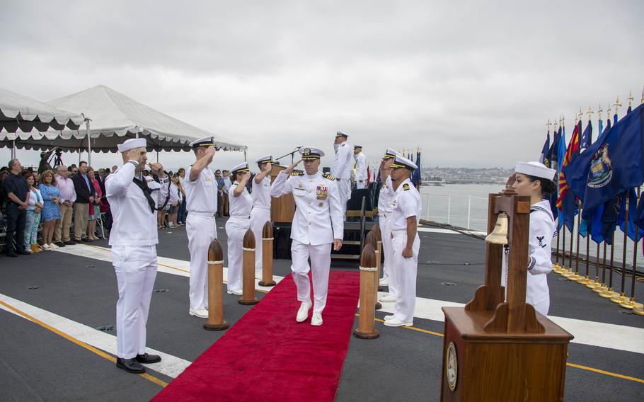 Capt. Peter J. Riebe, commanding officer of the Nimitz-class aircraft carrier USS Abraham Lincoln (CVN 72), is piped ashore during a change of command ceremony on the flight deck.