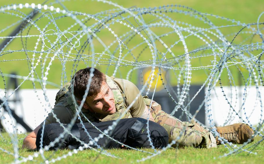 A Best Ranger competitor crawls through a razor wire obstacle during the second day of the Army’s annual Best Ranger Competition on Saturday, April 13, 2024, at A.J. McClung Stadium in downtown Columbus, Ga. 