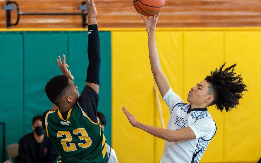 Zama’s Jarius Brown puts up a shot against Robert D. Edgren’s Frederick Stewart during Saturday’s DODEA-Japan boys basketball game. The Trojans won 64-61.