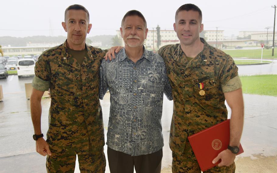Marine 1st Lt. Steven Ladine, far right, poses with Lt. Col. Caleb Eames and Tom Burkard after receiving the Navy and Marine Corps Medal at Camp Hansen Okinawa, Tuesday, June 7, 2022. 