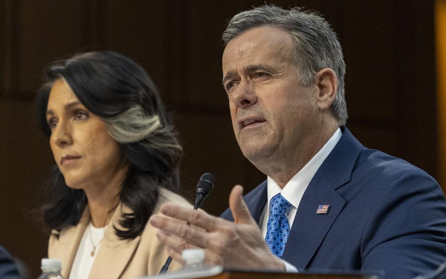 CIA Director John Ratcliffe gestures with his hand while speaking into a microphone and sitting next to Director of National Intelligence Tulsi Gabbard during a congressional hearing.