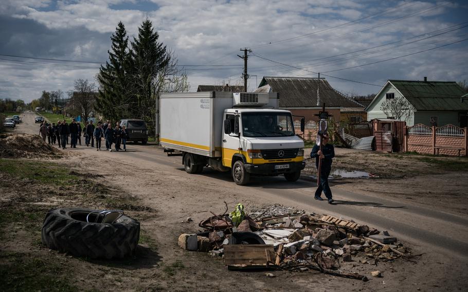 The funeral procession for Andriy Voznenko heads to a church cemetery in Ozera, Ukraine, where he will be buried for a second time.