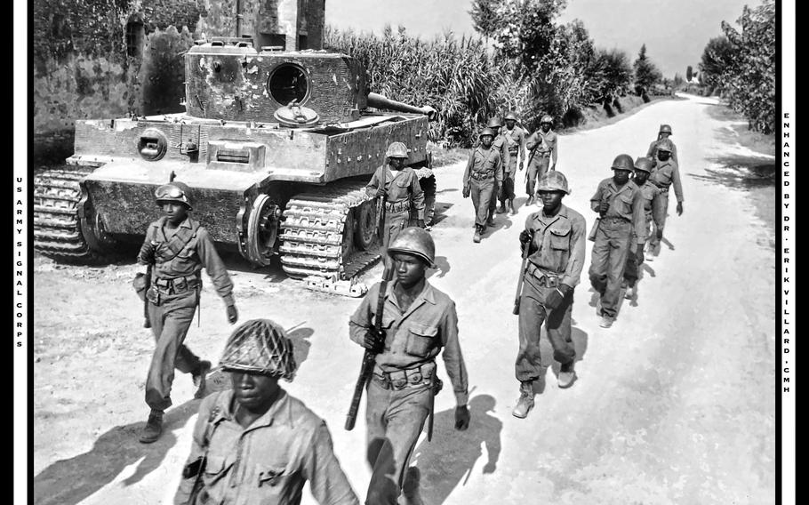 Troops from the 92nd Infantry Division move past a destroyed Mark IV tank on the outskirts of Ponsacco, Italy, on Sept. 1, 1944. 