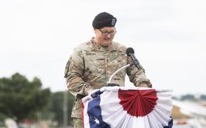 A man in Army uniform speaking at a podium.