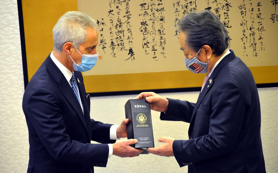 U.S. Ambassador to Japan Rahm Emanuel presents Yokosuka Mayor Katsuaki Kamiji with whiskey distilled in Chicago during their first meeting in Yokosuka, Japan, Feb. 17, 2022. 