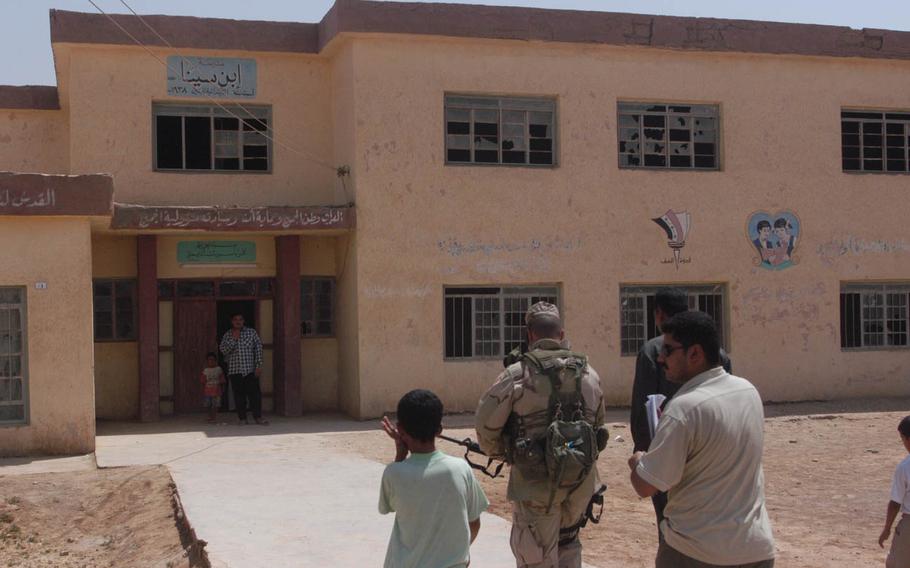 A soldier visits a damaged school
