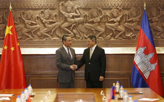In this photo released by Agence Kampuchea Press (AKP), Chinese Foreign Minister Wang Yi, left, greets with Cambodia's Foreign Minister, SOK Chenda Sophea, right, in Phnom Penh, Cambodia, Sunday, April 21, 2024. Wang Yi, arrived Cambodia to mark his 3 days official visit (21-23 April) Cambodia to reaffirm his country's commitment and to boost the already firmly tied to southeast Asian country, twice visited in the last eight months. (AKP via AP)