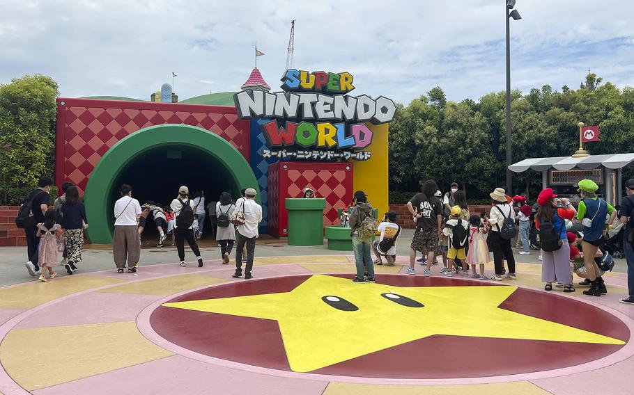 People gather near a giant green pipe that leads to Super Nintendo World at Universal Studios Japan in Osaka.