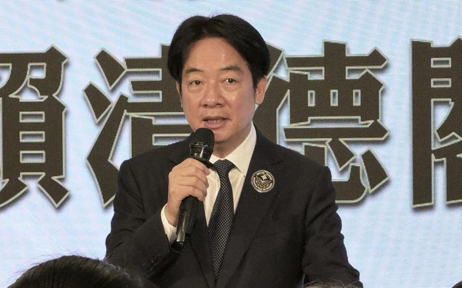 A man in a suit holds a microphone. 