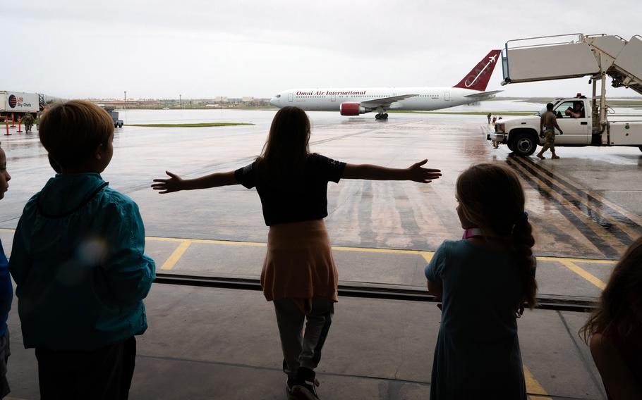 Children watch as the Patriot Express touches down in front of a temporary passenger terminal at Andersen Air Force Base, Guam, May 30, 2023. 
