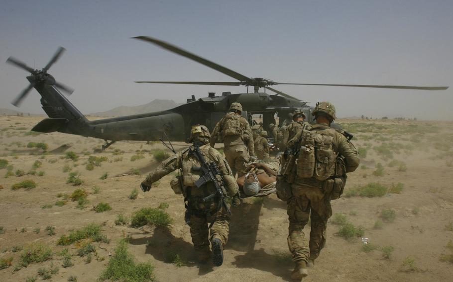 Sgt. William Bennett of 1st Battalion, 5th Infantry Regiment, 1st Stryker Brigade Combat Team is evacuated to a medevac helicopter after being injured in an improvised explosive device attack near Molla Dust in Kandahar province, Afghanistan, on June 15, 2011. 