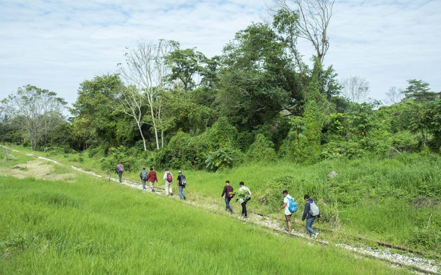 Migrants from Honduras walk along a railway track in Tenosique, Mexico, on March 8, 2021. 