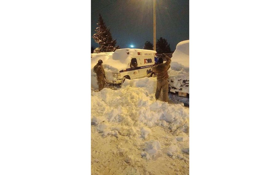 New York Army National Guard soldiers assigned to the 827th Engineer Company and airman assigned to the 174th Attack Wing help to clear snow to recover an AMR ambulance in Buffalo, N.Y., Dec. 26, 2022.