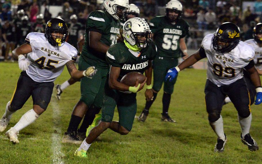 Kubasaki’s Carlos Cadet, trying to outrun Kadena’s Julius Gantz (45) and Ricardo Gantz (99), had the game’s lone offensive touchdown.