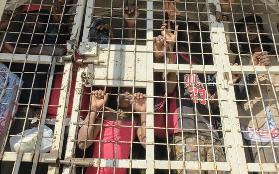 People who were detained for deportation to Haiti stand inside a police truck on the border bridge that connects Dajabon, Dominican Republic with Haiti, Monday, March 18, 2024. (AP Photo/Ricardo Hernandez)