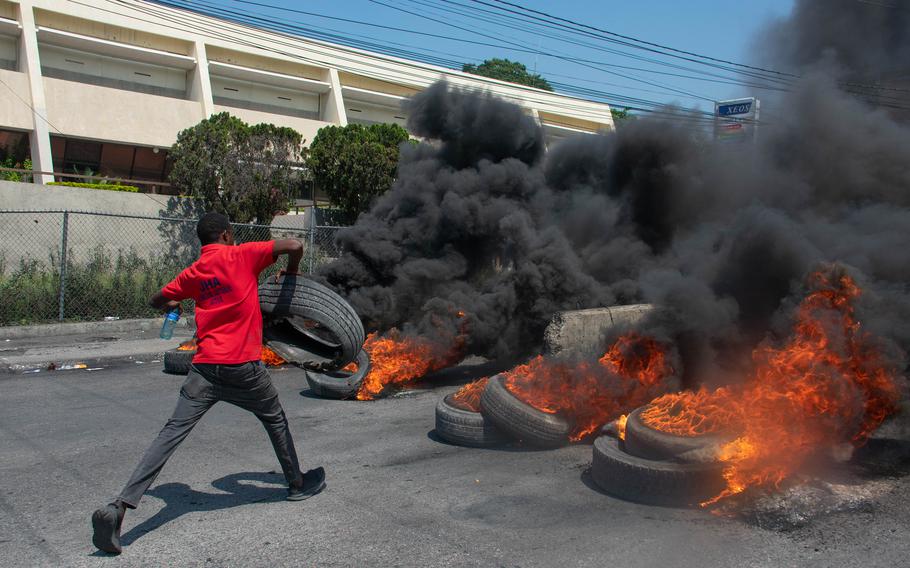 A protester burns tires during a demonstration following the resignation of its Prime Minister Ariel Henry, in Port-au-Prince, Haiti, on March 12, 2024. 