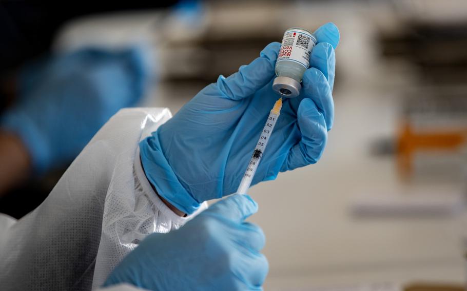 A health care professional measures a dose of COVID vaccine at a California vaccination site on Feb. 2, 2021. 