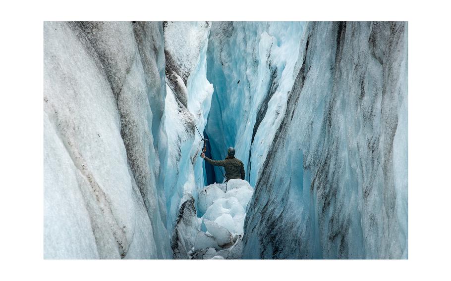 U.S. Army Staff Sgt. Ryan Earl, 2nd Infantry Brigade Combat Team, 11th Airborne Division, Glacier Mountaineering Team lead mountaineer, peers into a deep crevasse in search of possible human remains, personal effects and equipment between glacier ridges at Colony Glacier, Alaska, June 16, 