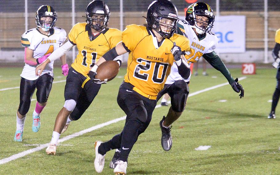 American School In Japan running back Noa Grasse cuts around right end ahead of Robert D. Edgren defender Noah Medonis en route to an 84-yard touchdown run.