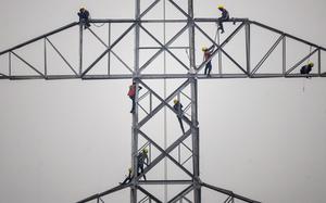 Technicians work on an unconnected transmission tower. MUST CREDIT: Dhiraj Singh/Bloomberg.