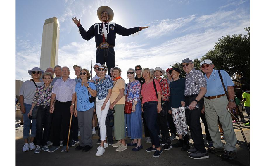 Vietnam veterans and their wives pose for a photo in front of Big Tex at the State Fair of Texas on Oct. 10, 2023.