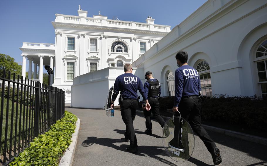 Members of U.S. Secret Service carry riot shields on a driveway at the White House in Washington on April 20, 2021. 