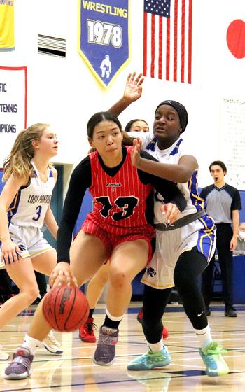 Nile C. Kinnick's Amyka Jones drives to the basket as Yokota's Beverly Gardner defends.