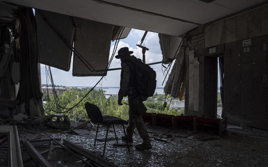 A Ukrainian serviceman walks inside of the headquarters of the Mykolaiv Regional Military Administration building destroyed by a Russian attack in Mykolaiv, Ukraine, Friday, Aug. 5, 2022.