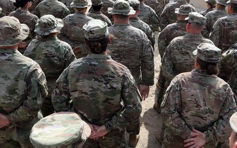 Soldiers stand in formation during a ceremony in Kuwait in 2018. A study of more than 1,400 combat-deployed soldiers, published Jan. 24, 2023 in JAMA Psychiatry, found that reports of being bullied or hazed during a combat deployment were associated with a variety of consequent mental health conditions.