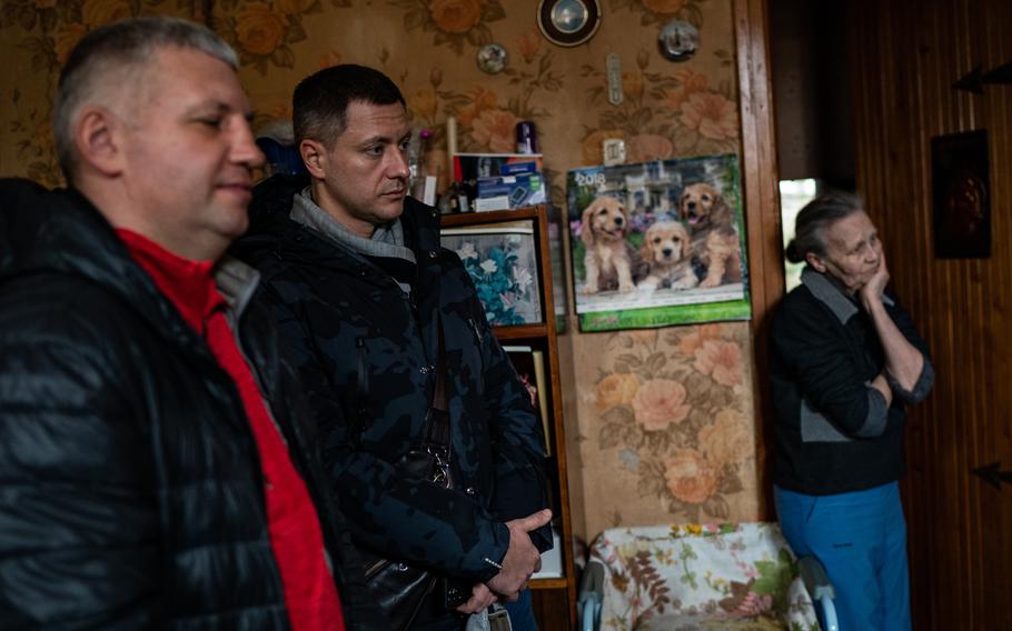 Maksim Gaida, left, and Eduard Shevchenko chat with Anna Churilyana, 90, after delivering her groceries in Odesa, Ukraine, on March 6, 2022. 