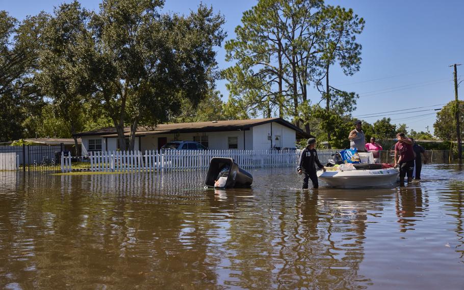 A resident assists neighbors through flooded streets in Orlando, Florida, on Sept. 30.