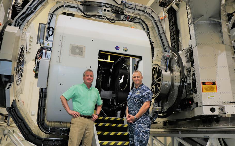 Naval Medical Research Unit Dayton’s Senior Research Psychologist Dr. Henry Williams (left) and Capt. Richard Folga, Naval Aerospace and Operational Physiologist, Disorientation Research Device (DRD) Program Manager and Engineering and Technical Support Services Department Head stand near the DRD.  The DRD, or the Kraken, is the Navy’s aerospace medicine research device.