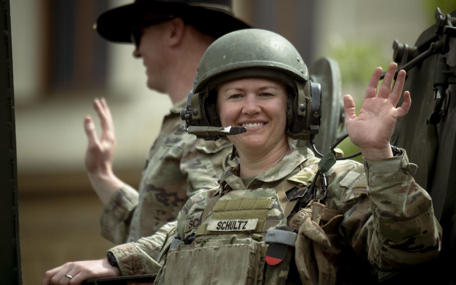 A soldier smiles and waves.