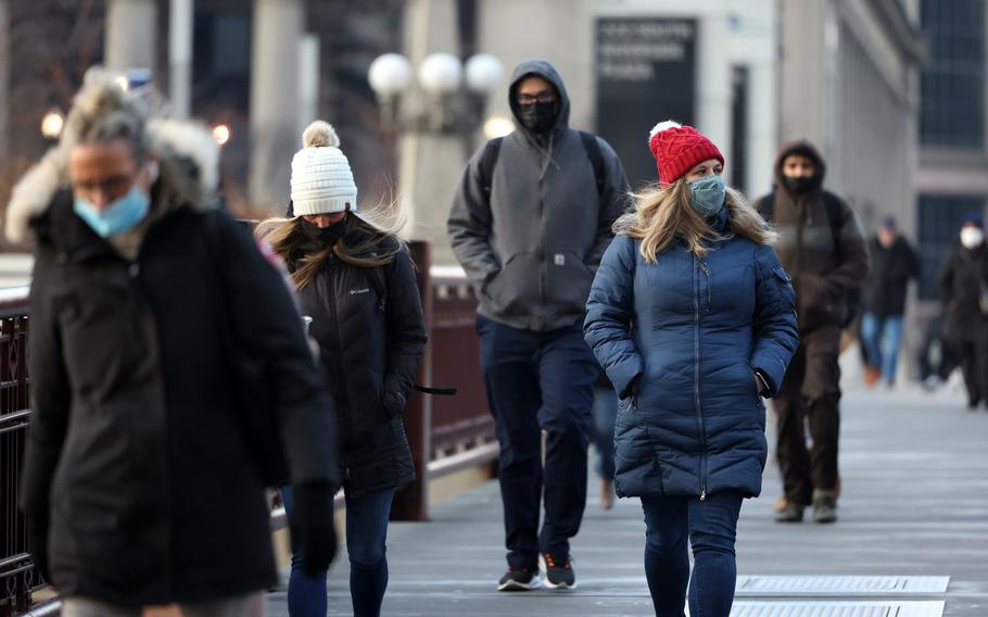 Commuters cross the Adams Street bridge outside Union Station in Chicago during the morning rush on Dec. 21, 2021.