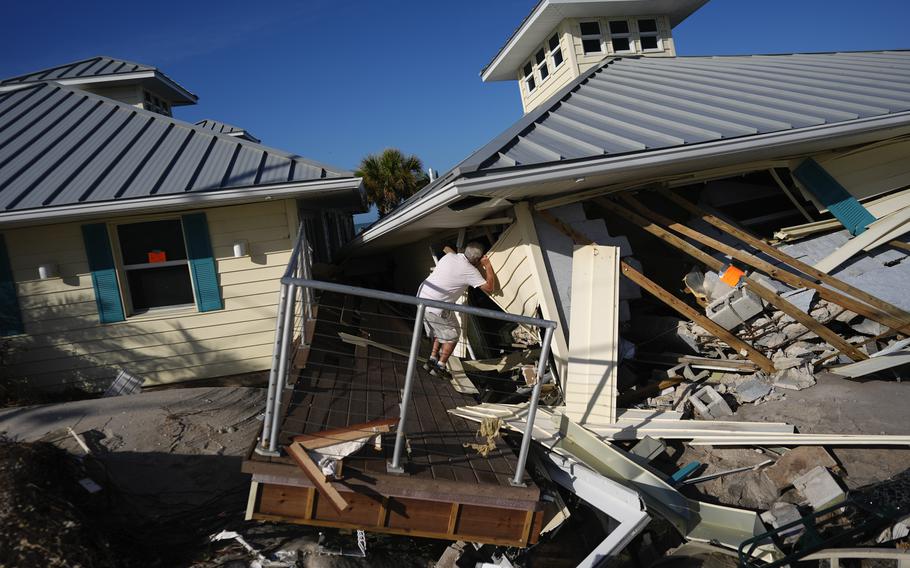 A property owner peers into the hurricane-destroyed remains of the second floor unit where he lived.
