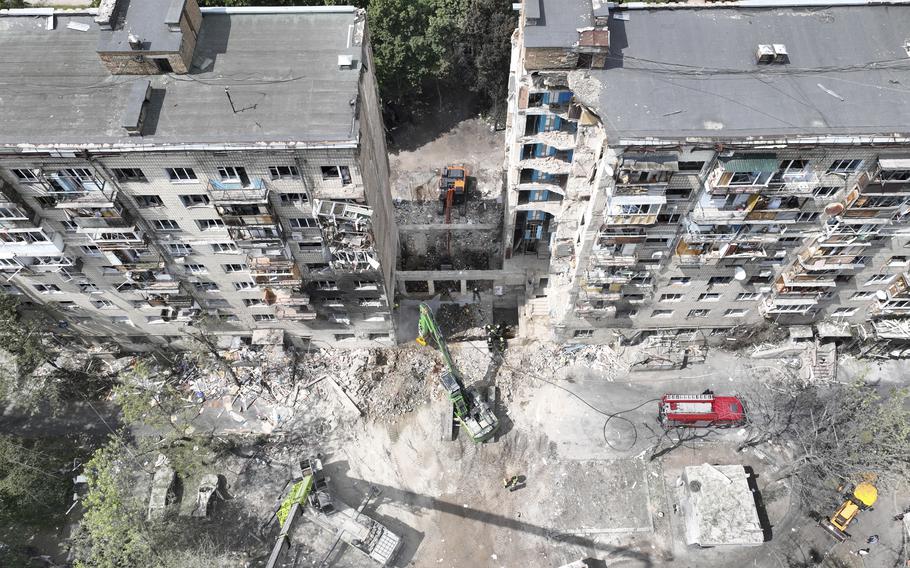 An aerial photo of a damaged apartment complex, which is missing a middle portion.