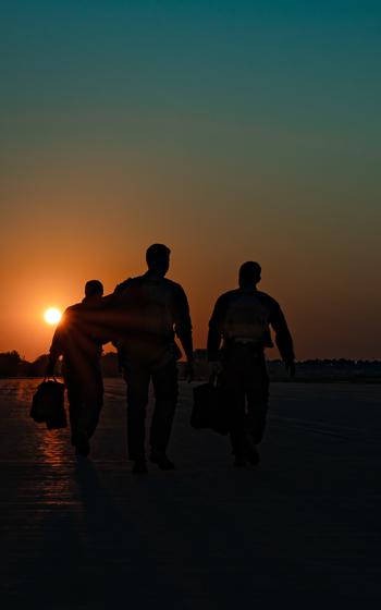 Three airmen walk together.