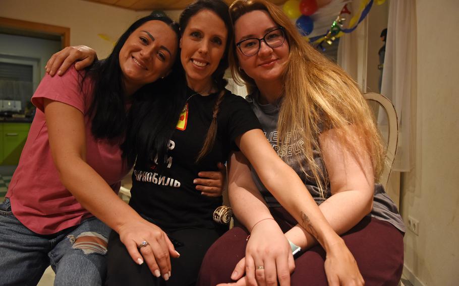 Jessie Bledsoe, center, an Air Force spouse, sits between two Ukrainian women who fled the war in Ukraine with their family, March 16, 2022.  Bledsoe, who helped start and lead Operation Ukrainians to Ramstein, a nonprofit group to help refugees fleeing the war in Ukraine get settled in Germany, is hosting seven Ukrainians in her home near Ramstein Air Base, Germany. The group is looking for more host families in the Kaiserslautern military community.