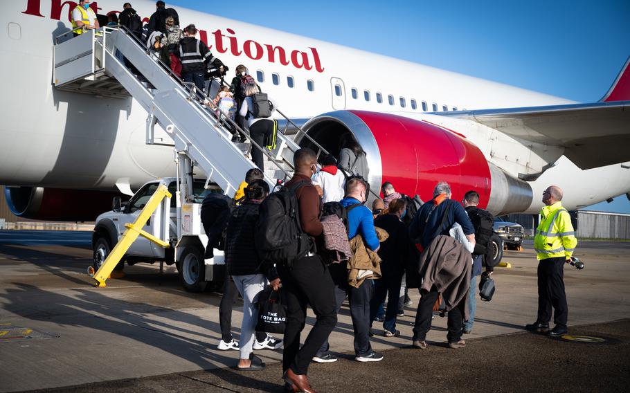 Passengers board the Patriot Express at RAF Mildenhall, England, Dec. 20, 2022. The Air Force is still processing new military assignments, and moves scheduled this year haven’t been canceled, the service said, following concerns and posts by airmen on unofficial social media channels.