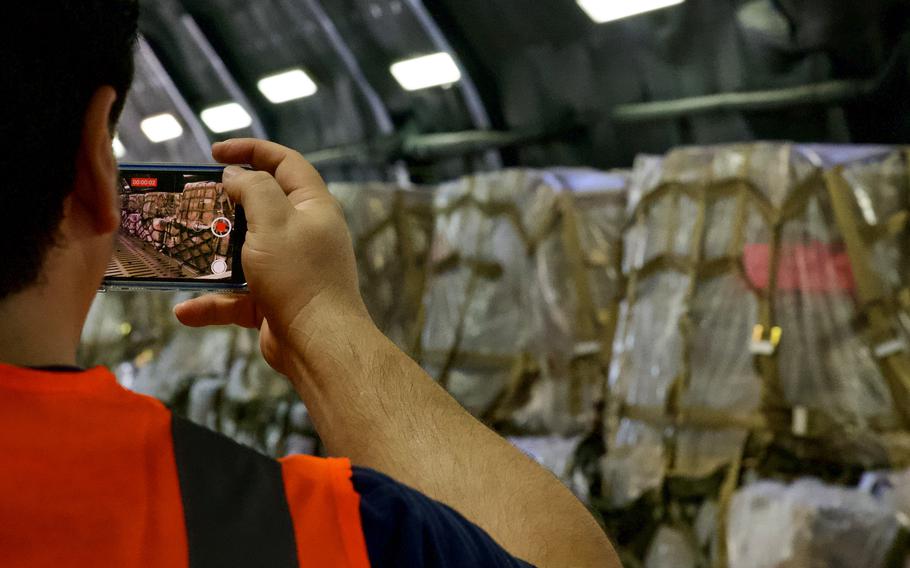 A person takes a photo of food pallets.