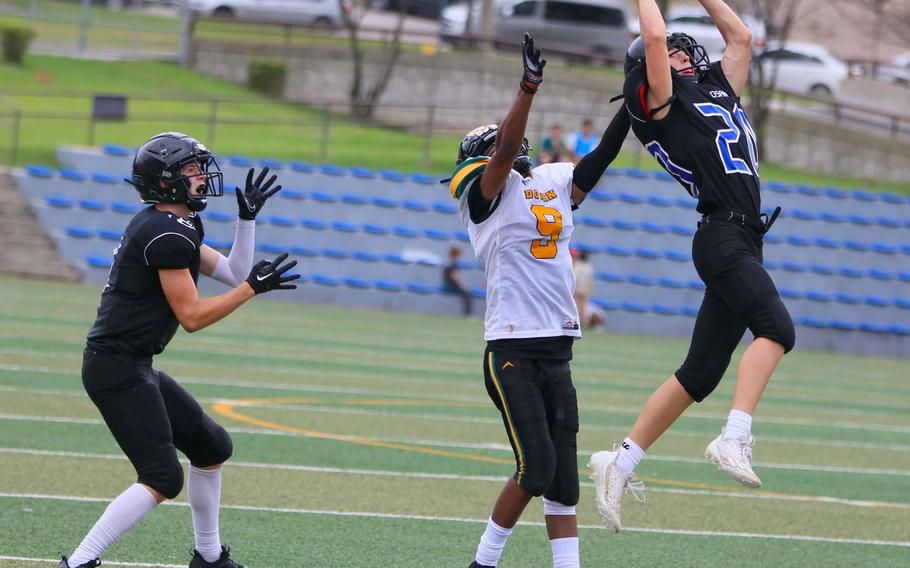 Osan's Dimitri Mock and Robert D. Edgren's Daniel Phillips go up for a pass as Osan's Asher Horne watches.