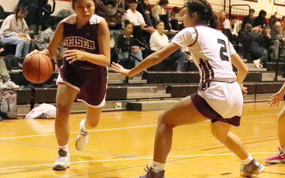 Seisen's Aina Sekido dribbles against Zama's Isabella Rivera-Munoz during Wednesday's Kanto Plain girls basketball game. The Trojans won 38-37, rallying from six points down with two minutes left.