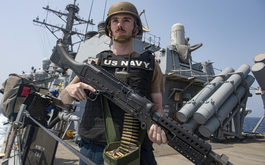 Logistics Specialist 3rd Class Anthony Crane holds an M240B machine gun on the aft missile deck of the guided-missile destroyer USS Paul Hamilton during a Strait of Hormuz transit June 17, 2023. Paul Hamilton is deployed to the U.S. 5th Fleet area of operations to help ensure maritime security and stability in the Middle East region.