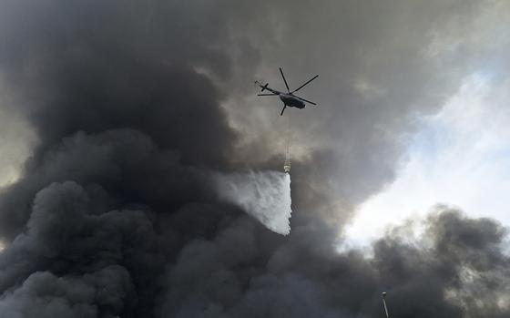 A helicopter drops water on the fire, Sunday, April 27, 2025, after a massive explosion and fire rocked a port near the southern port city of Bandar Abbas, Iran on Saturday. (AP Photo/Meysam Mirzadeh/Tasnim News)