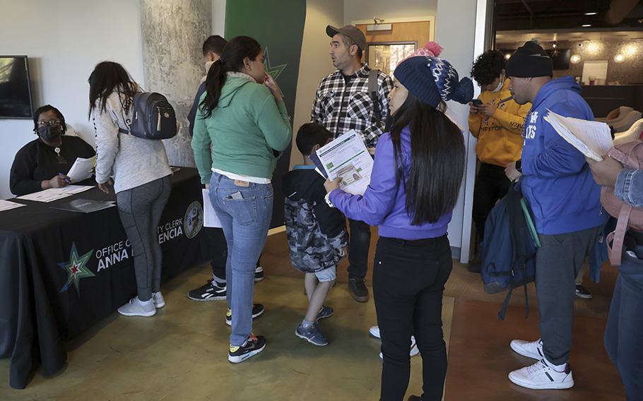 Migrants line up to obtain city identification from city employees at Park Community Church on April 26, 2023. 