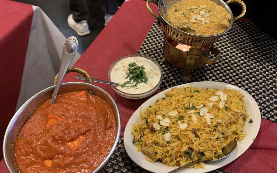 The menu at Taj Mahal Ristorante Indiano in Naples, Italy is extensive, with a variety of meat and vegetarian dishes.  Clockwise from bottom left are butter paneer, raita, chicken shahi korma and gosht biryani rice with mutton. 