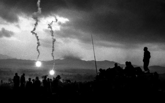 South Vietnam, January, 1968: Flares fall over Hill 50, west of Landing Zone Ross, silhouetting troops from 2/12, 1st Cavalry on a three-day operation in Que Son Valley. 