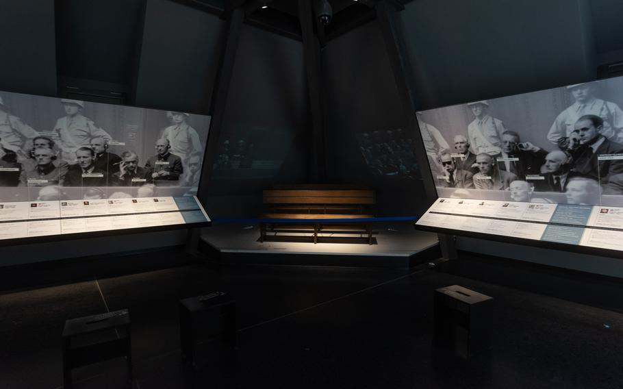 Benches in the Memorium Nuremberg Trials exhibition in Nuremberg, Germany, represent the prisoners dock. Scenes of Nazi defendants in the first trial are projected on the wall behind the benches.